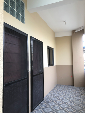 Room with small kitchen and bed